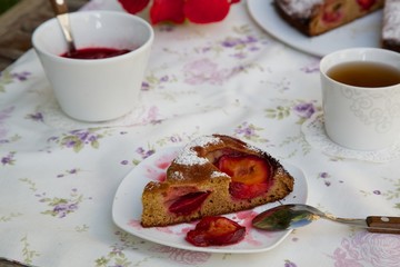 A piece of plum pie on a plate on a festive table.