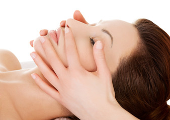 Woman relaxing in spa by getting face massage