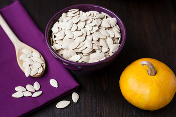 Bowl with toasted pumpkin seeds and wooden spoon