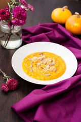 Pumpkin cream-soup with seeds in a plate