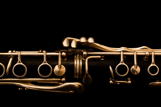 Detail of the clarinet in golden tones on a black background