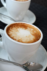 Cup of hot cappuccino on the black background