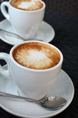 Cup of hot cappuccino on the black background
