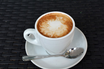 Cup of cappuccino on the black background