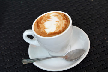 Hot cappuccino cup on the black background