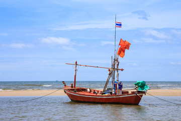 Obraz premium Traditional fishing boat on beach and blue sky