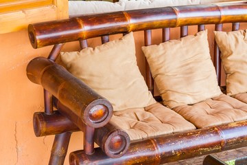 close-up of brown bamboo chair with pillow