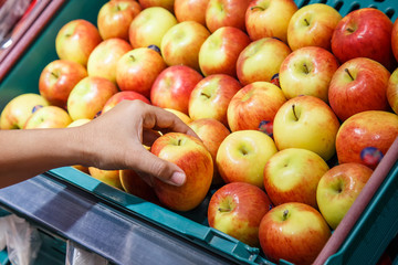 Hand holding apple in department store