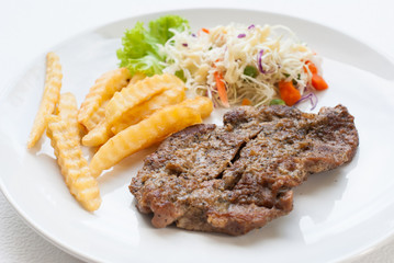 steak served with crisp golden French fries and fresh green herb