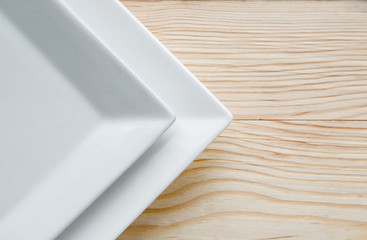 Square white plates over wooden table