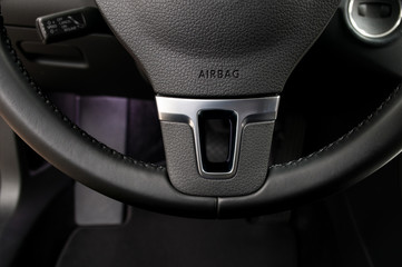 Airbag sign on steering wheel of car. Interior detail.