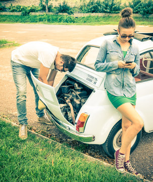 Couple in a moment of troubles during a vintage classic car trip