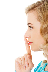 Side view of a woman making silence gesture