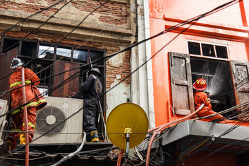 Fireman using water hose to prevent fire