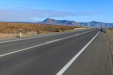 Road in desert landscape with mountains, Fuerteventura island