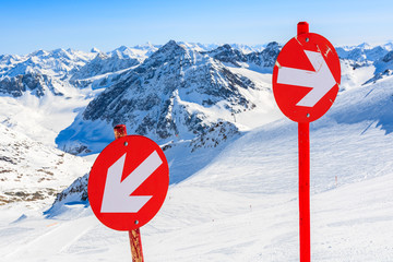 Red signs on ski slope in ski resort of Pitztal, Austrian Alps