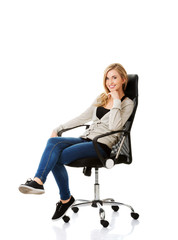 Fototapeta premium Young woman sitting on armchair touching chin