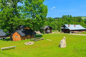 Wooden mountain houses on green field in summer, Pieniny, Poland