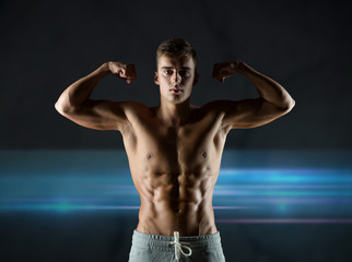 Fototapeta na wymiar young man showing biceps and muscles