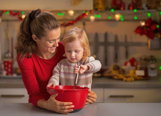 Happy mother and baby whisking dough 