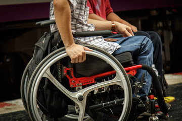 Fototapeta premium Close-up of male hand on wheel of wheelchair