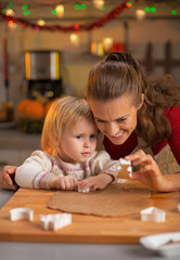 Portrait of mother and baby making christmas cookies