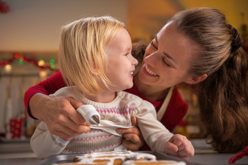 Portrait of happy mother and baby making christmas cookies - obrazy, fototapety, plakaty
