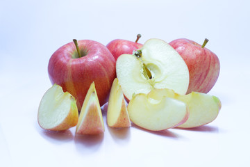 Red apple with leaf and slice on a white background.