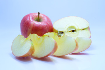Red apple with leaf and slice on a white background.