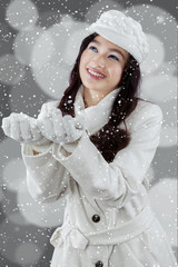 Cheerful woman playing snowfall