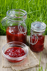 Fototapeta na wymiar Raspberry jam on wooden tray in the garden