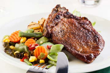 Fried pork with potatoes and vegetables salad