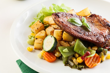Fried pork with potatoes and vegetables salad