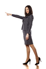 pretty young businesswoman pointing at empty space