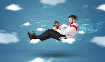 Funny racedriver young man driving between clouds concept