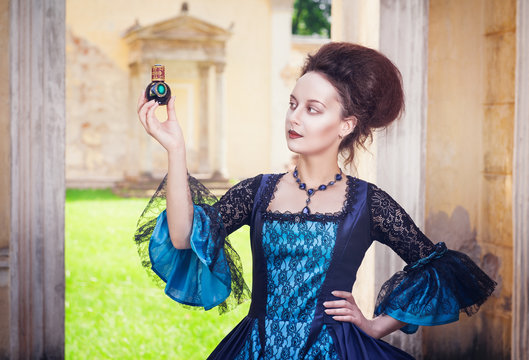 Beautiful Woman In Medieval Dress With Perfume Bottle