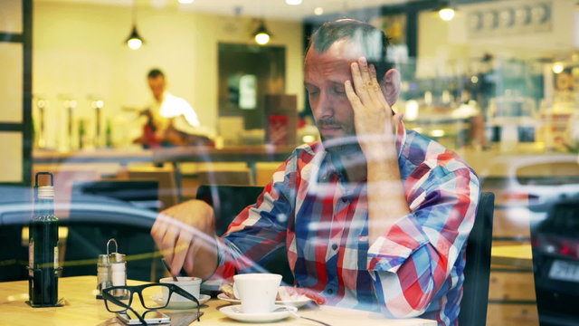 Man having headache and sitting in the restaurant, steadycam 