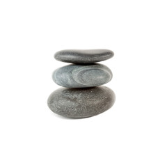 Three smooth stones on each other over white