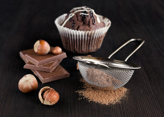chocolate muffins with cocoa , chocolate bars and hazelnuts