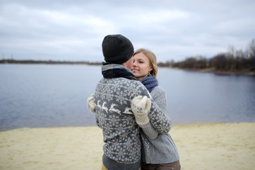 the guy and the girl walk on a desert autumn beach