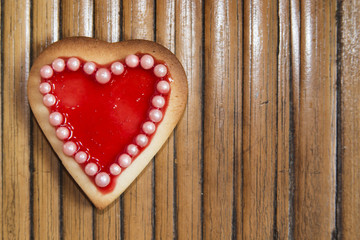 Red heart cookie on wooden background