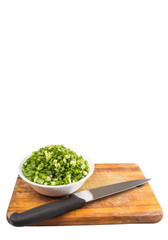 Chopped scallions or spring onion leaves in a white bowl 