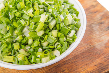 Chopped scallion or spring onion leaves in a white bowl