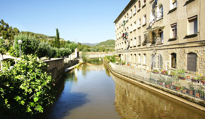 Fototapeta premium Bloque de pisos y canal en Castellbell i El Vilar, Barcelona