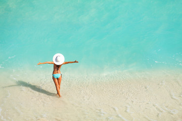 Top view of woman with white hat standing in ocean