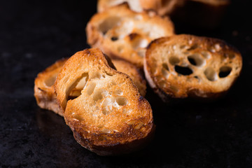 Toasted crusty baguette  on old black background