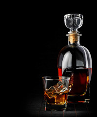 Studio shot of whiskey in a carafe and glass isolated on black