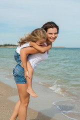 Mother and her daughter  having fun on the beach