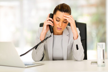 stressed businesswoman talking on telephone