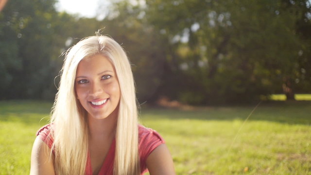 Cheerful beautiful blonde woman outdoors smiling